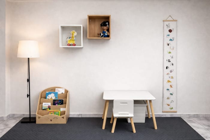 Área de juegos con mesa infantil, libros y juguetes